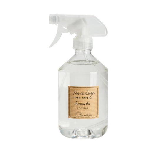 A clear glass spray bottle with a white trigger sprayer and a beige label reading 'Eau de Toilette' and 'Lavande'.